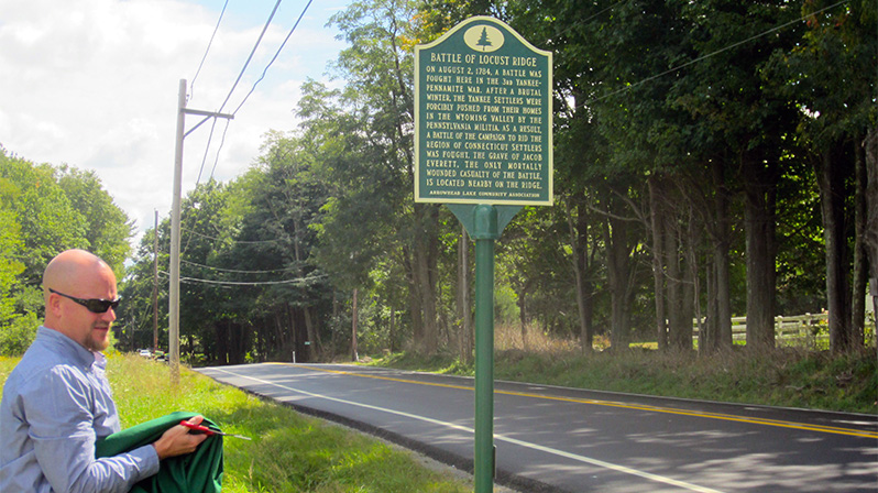 Eric Usbeck, general manager of the Arrowhead Lake Community Association, unveils the marker.
