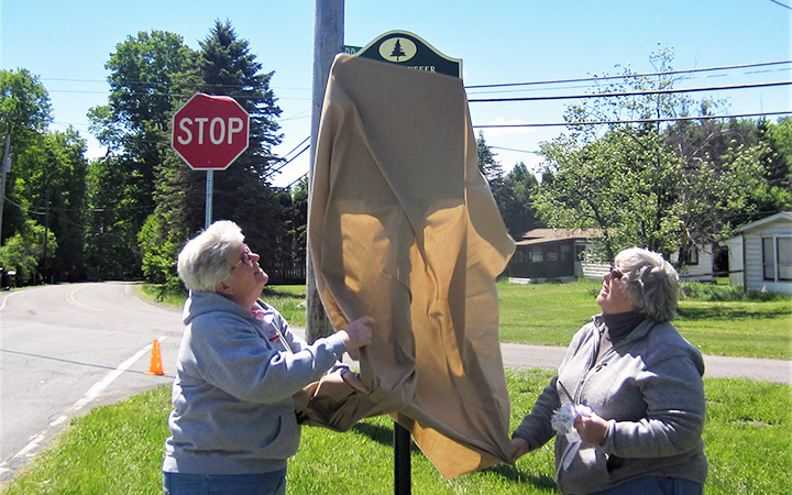 Judy Avery, left, and Kris Avery unveil the Isaac Stauffer marker on June 3, 2017.